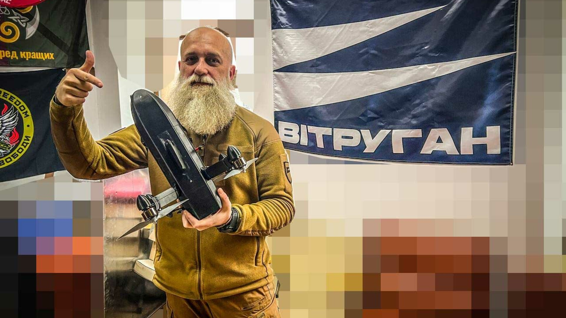 Man holding a compact drone beside a WeTrueGun banner